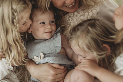 Portrait of baby girl while surrounded by sisters and mother