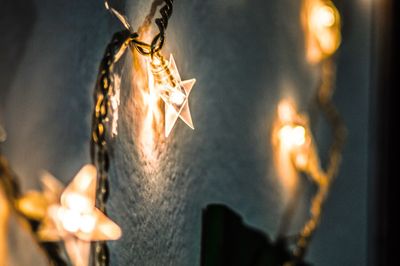 Close-up of illuminated lights against sky at night