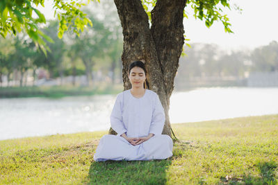 Portrait of smiling young woman sitting on field