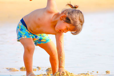 Girl child is playing in the sand on beach