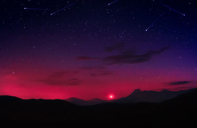Scenic view of silhouette mountain against sky at night