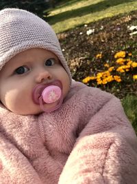 Portrait of cute baby girl with pacifier in mouth