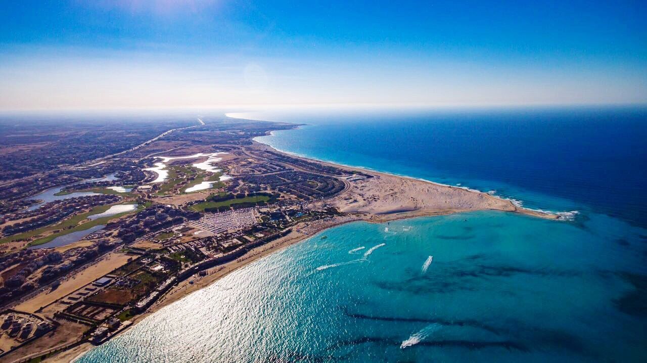 AERIAL VIEW OF SEA WITH CITYSCAPE IN BACKGROUND