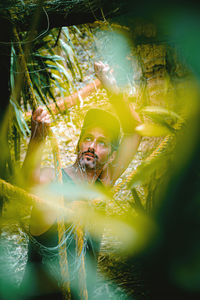 Man in forest seen through net