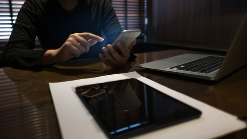 Midsection of man using mobile phone