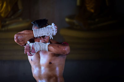 Portrait of shirtless sweaty man exercising