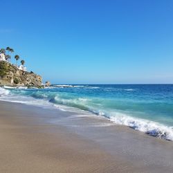 View of beach against clear blue sky