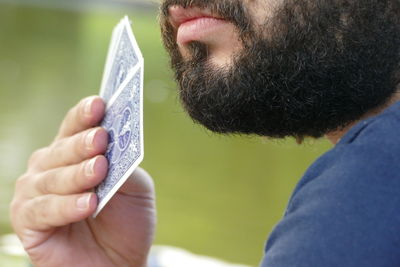 Midsection of young man playing cards