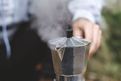 Close up of a man preparing coffee outdoors