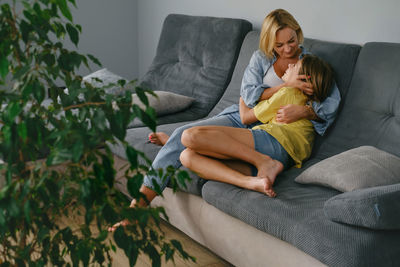 Portrait of woman sitting on sofa at home