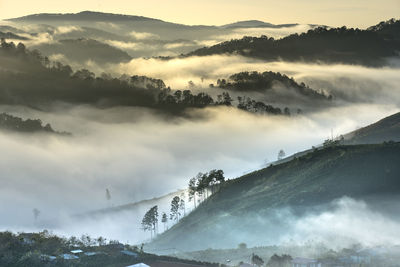 Scenic view of mountains amidst clouds during sunset