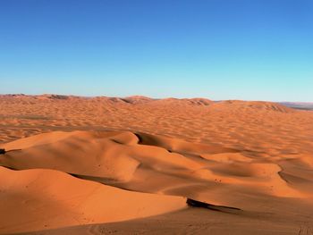 Scenic view of desert against blue sky