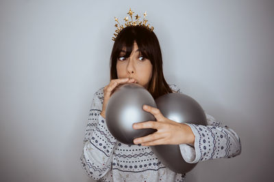 Portrait of young woman exercising against wall