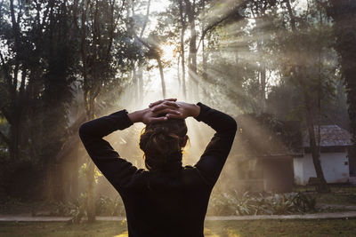 Rear view of woman standing in forest