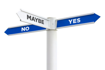 Low angle view of road sign against white wall