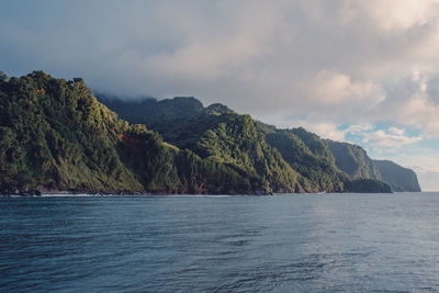 Scenic view of sea and mountains against sky