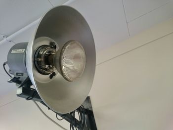 Low angle view of spotlight mounted on wall