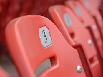 Close-up of number 3 on orange chair at stadium