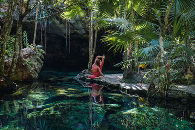 Woman doing a yoga pose in a cenote