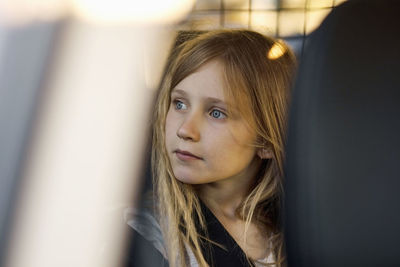 Girl sitting in electric car while looking away