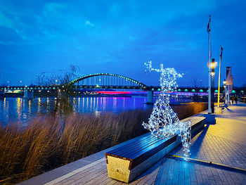 Illuminated bridge against sky at night