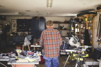 Rear view of senior man standing in workshop