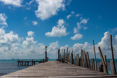 Wooden pier on sea against sky