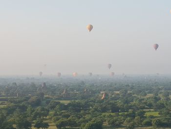 Hot air balloon flying over landscape against sky