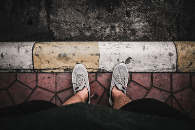 Low section of man standing on footpath