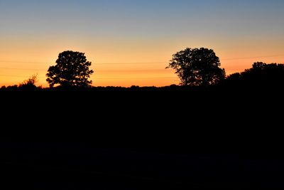 Silhouette trees against sky during sunset