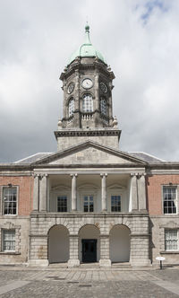 Low angle view of building against cloudy sky