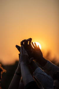 Cropped hand of woman holding illuminated string lights