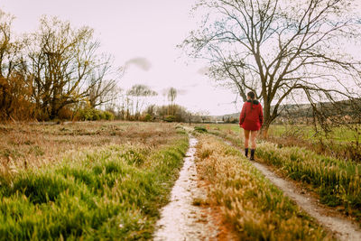 Rear view of woman walking on footpath