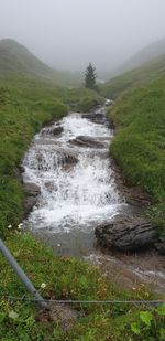 Scenic view of waterfall against sky