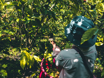 Rear view of man standing by plants