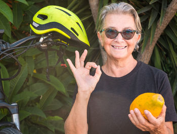 Portrait of smiling woman holding papaya