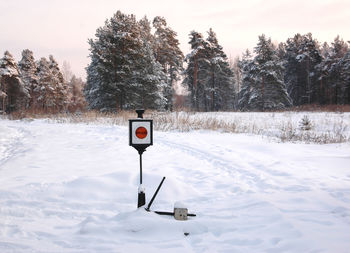 Road signal on snowcapped road during winter