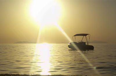Silhouette boat in sea against sky during sunset