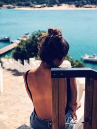 Rear view of woman sitting on beach