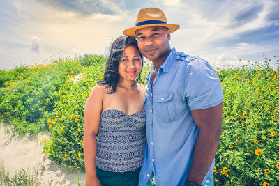 Young couple standing against plants