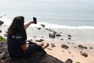 Woman photographing on beach