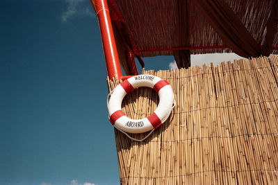 Heart shape hanging on roof against sky