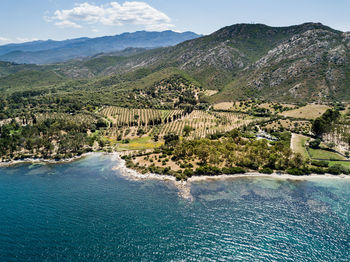 Scenic view of river by mountains against sky