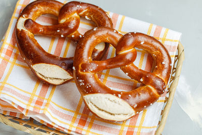 Two traditional soft octoberfest pretzels in bread basket, close-up