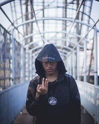 Portrait of young man standing against wall