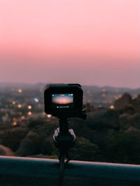 Man photographing camera on mobile phone against sky