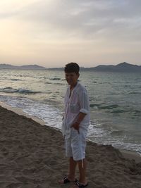 Full length of man standing on beach against sky