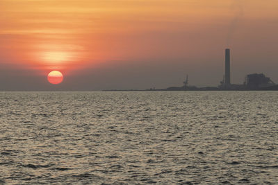 Scenic view of sea against orange sky