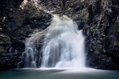 Waterfall flowing on rock formation in forest