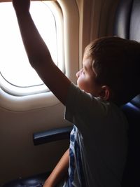 Boy looking at airplane window